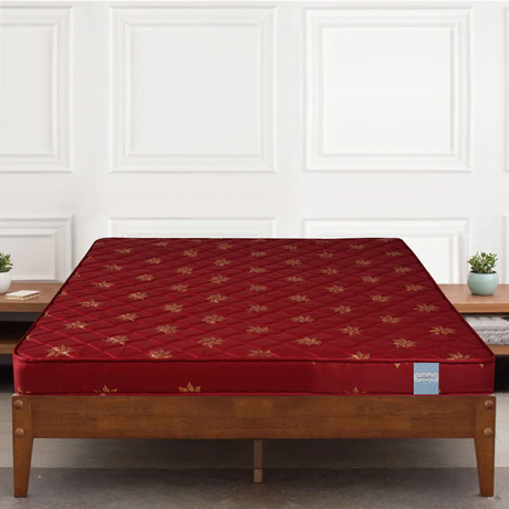 Classic Amaze Eco HD Foam Mattress mattress with gold patterns on a wooden bed frame against a white paneled wall.