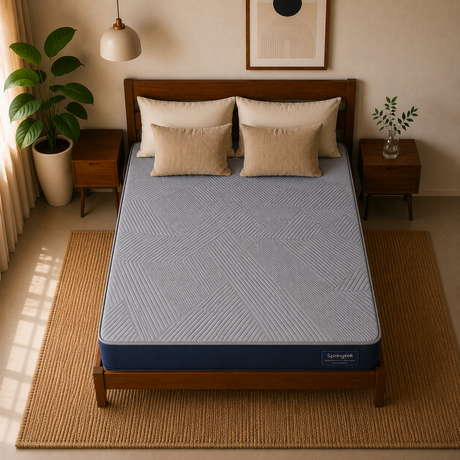 A bed with a light blue patterned Springtek Ortho Pocket Memory Foam Spring Mattress and matching pillows in a styled bedroom setting with wooden furniture, plants, and warm neutral decor.